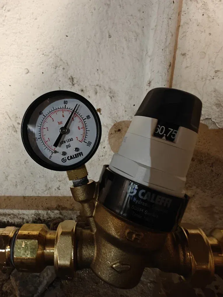 A pressure-reducing valve with a test gauge. High street pressure is a common hidden cause of leaks and failed fixtures.